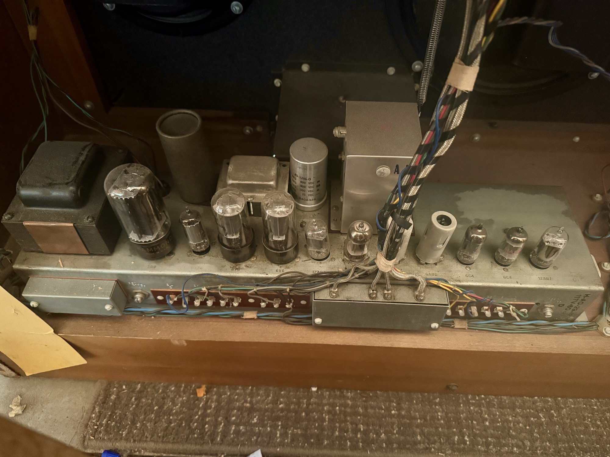 the inside of a Hammond M100 organ. An orderly assortment of tubes of different sizes, along with a collection of wires wrapped neatly